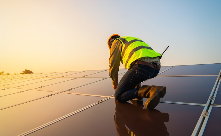 man installing solar panels on a roof